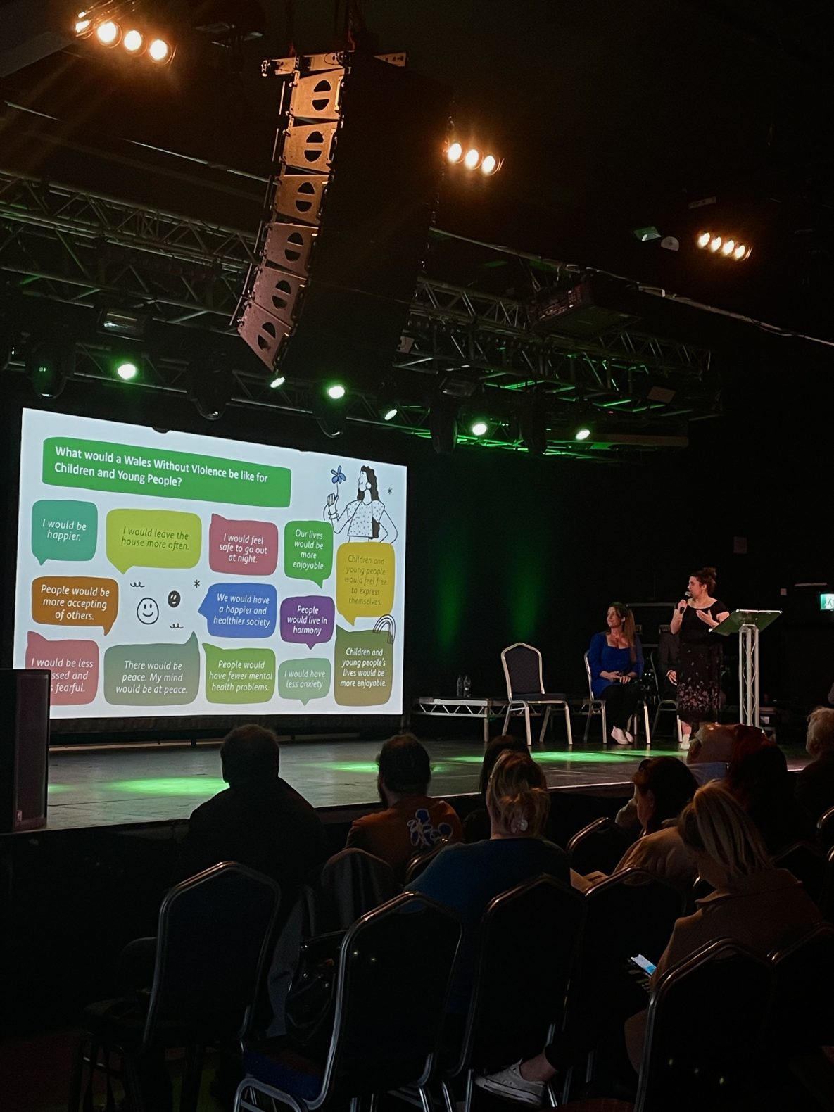 This image shows presenters talking through their slides and reading aloud children and young people's views on a Wales without violence.